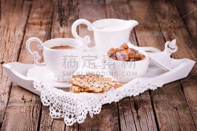 咖啡、牛奶和饼干放在托盘上