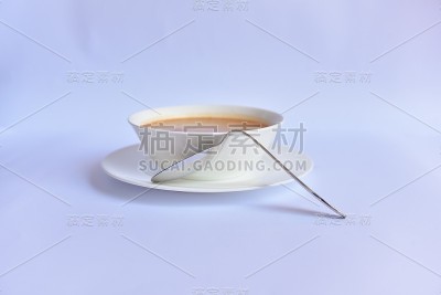 白色汤碗旁边倾斜的金属勺子，缺乏功能