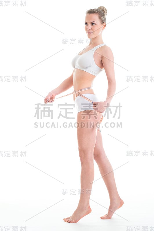 迷人的女人与厘米测量她的苗条美丽的身体在白色的背景