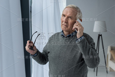 一位自信的资深男士正在打电话