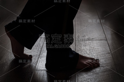 女人的腿放在温暖的木地板上