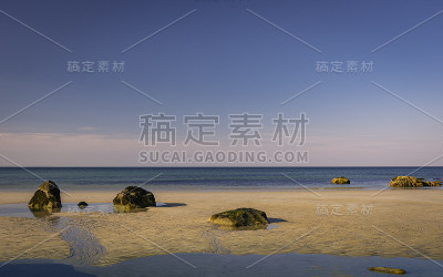在低潮背景的彩色沙滩上放置的大石头像禅宗一样