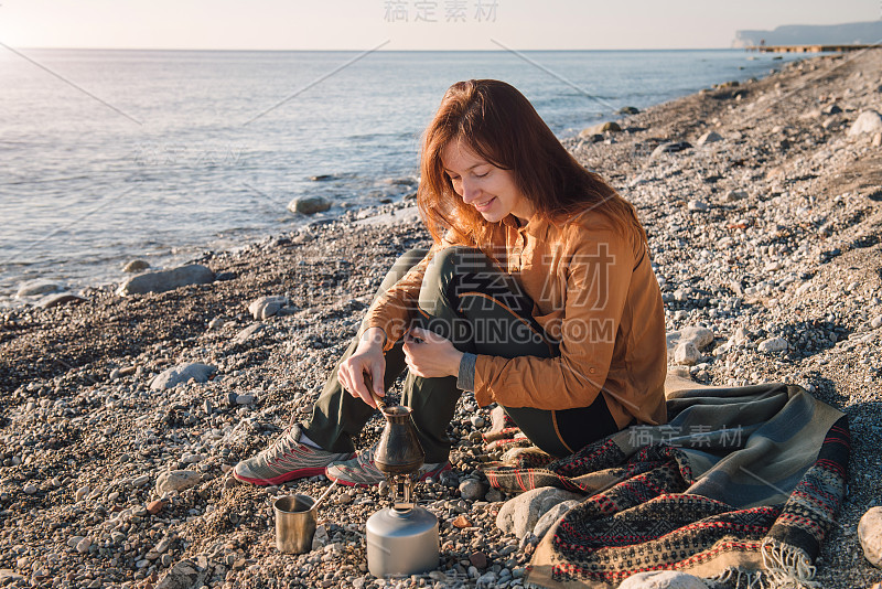 年轻女子在海边煮咖啡