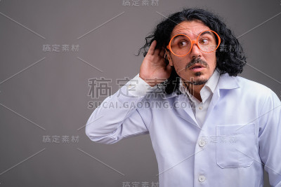 工作室拍摄的年轻英俊的男子医生与灰色的背景胡子