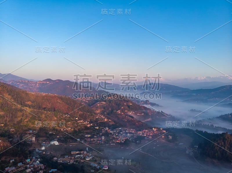 日出时大雾笼罩的山脉，以喜马拉雅山脉为背景。