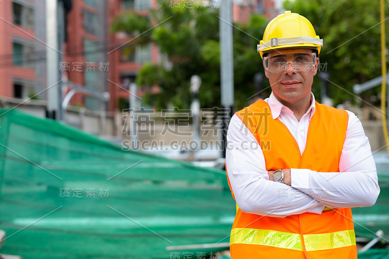 在建筑工地上英俊的波斯男子建筑工人的肖像