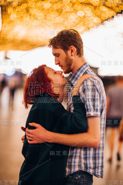 幸福的夫妇拥抱和亲吻在晚上的一个轻花环