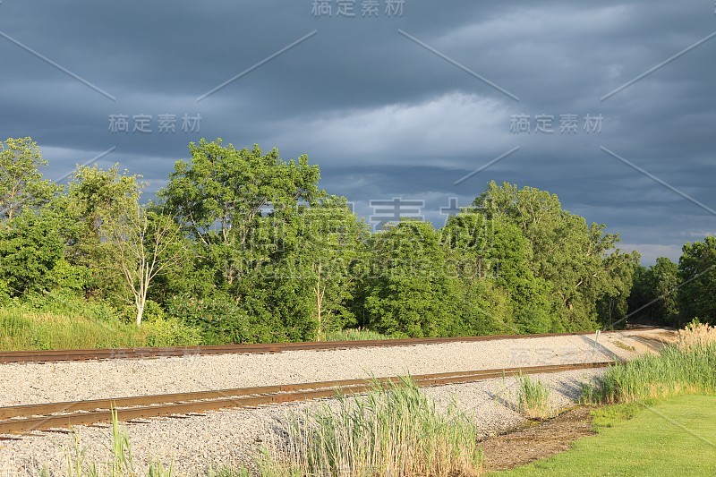 在纽约莱克维尔，阳光明媚的铁路轨道上，暴风雨般的天空