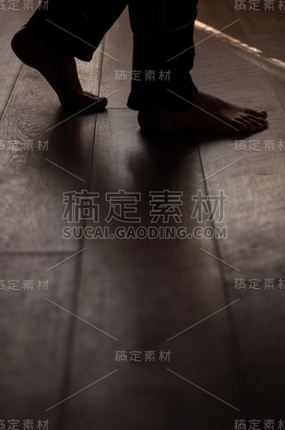 女人的腿放在温暖的木地板上