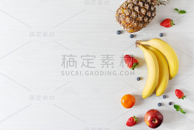 创意构图不同的水果和蔬菜在白色木桌的背景上俯视图。