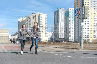 步行的女友在柏油人行横道上奔跑