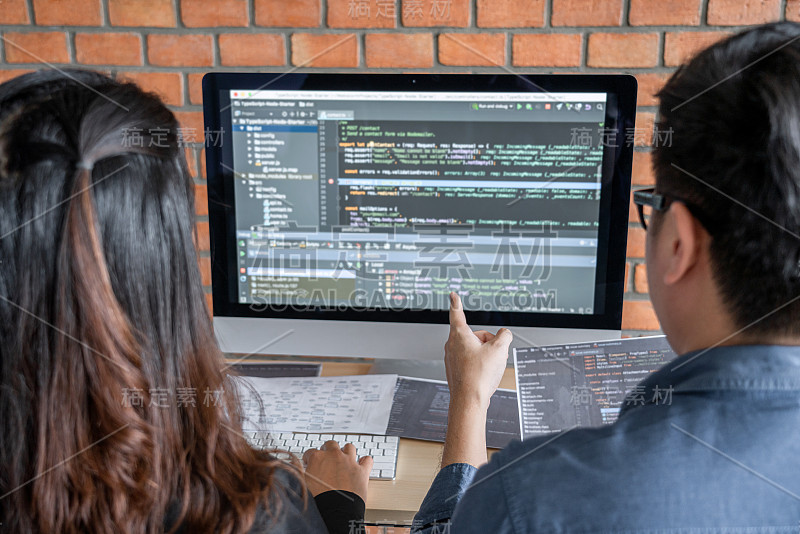 程序员合作开发编程和网站工作在一个软件开发公司的办公室，编写代码和输入数据代码，编程与HTML, P