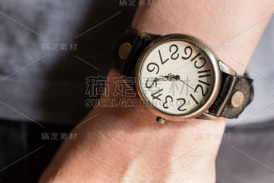 左手腕上戴着一块旧表的男人