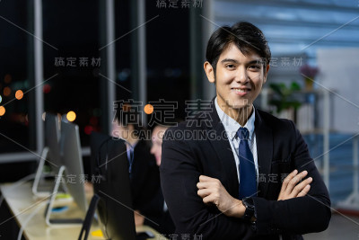 与同事团队在呼叫中心办公室加班到深夜。