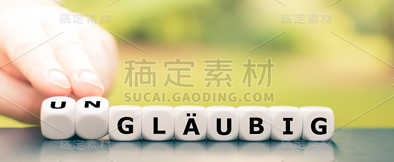 手转动骰子，改变德语单词“gläubig”(宗教)到“ungläubig”(无宗教)。
