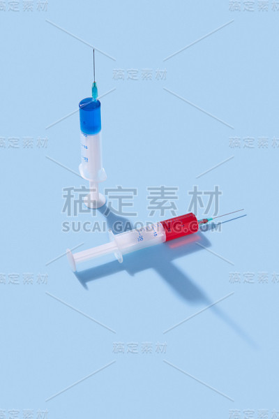 带有阴影的红色和蓝色疫苗一次性注射器。