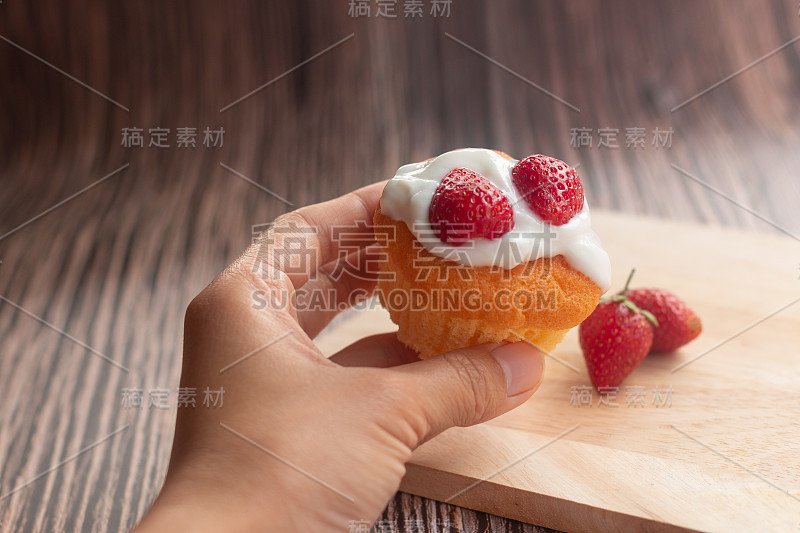 年轻女子用手接住木盘上的草莓蛋糕、面包和食物。