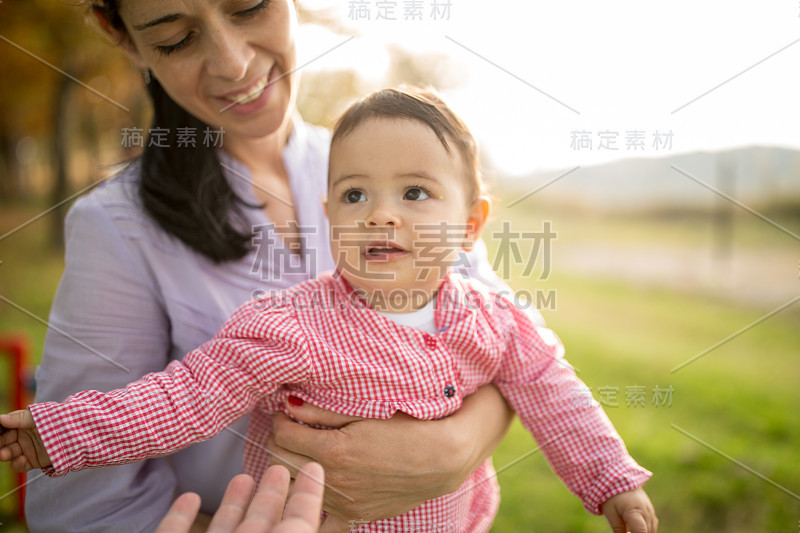 妈妈和她的小女儿在阳光灿烂的日子里在公园里玩得很开心