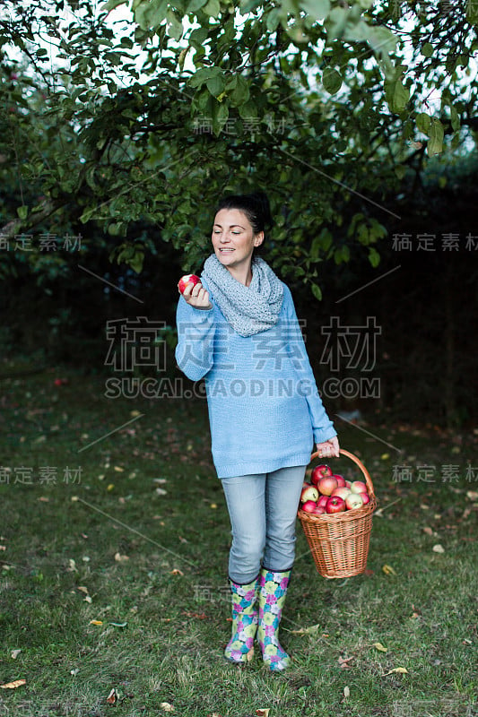 一位女农民在花园里享受自家种的苹果