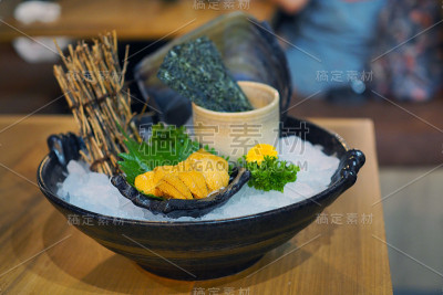 新鲜海胆或海胆生鱼片放在小碗里，盖在欧巴叶上，冰和干海草一起食用。
