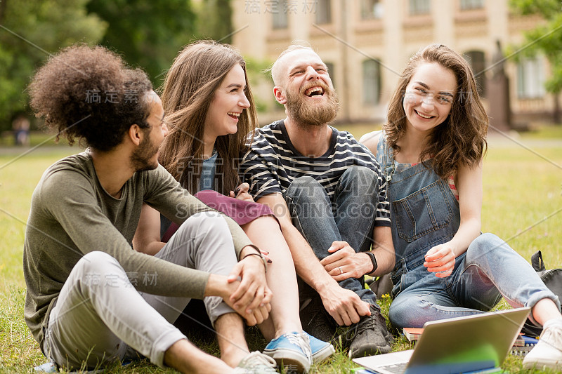 学生们在大学公园的草地上快乐地笑着。