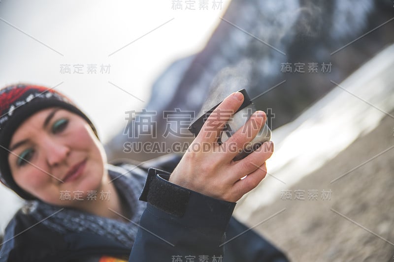 户外荒野探险:一个白人女孩正在喝着一杯金属茶