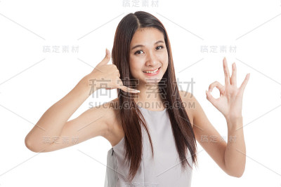 年轻的亚洲女子用手机手势和OK手势表示