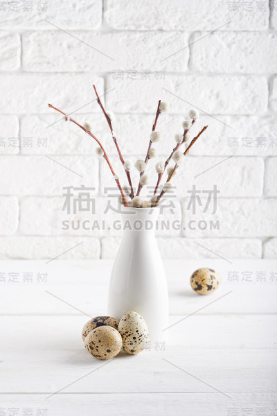 白色花瓶与柳枝，鹌鹑蛋和杯子在白色桌子复制空间复活节概念
