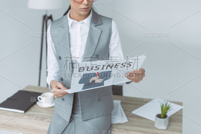 裁剪图像的女商人阅读报纸孤立在灰色