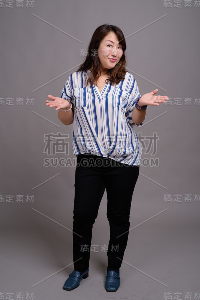 工作室拍摄的成熟美丽的亚洲女商人在灰色的背景