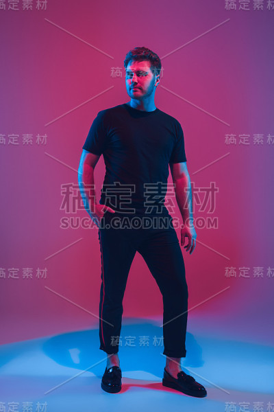 年轻的白人音乐家在霓虹灯下唱歌跳舞