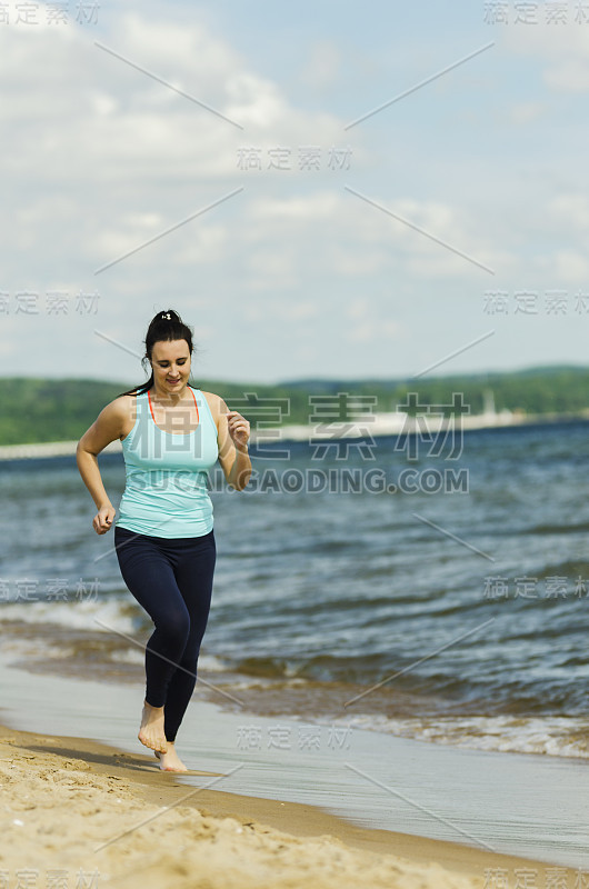 迷人的年轻女孩在夏天的海滩上锻炼身体