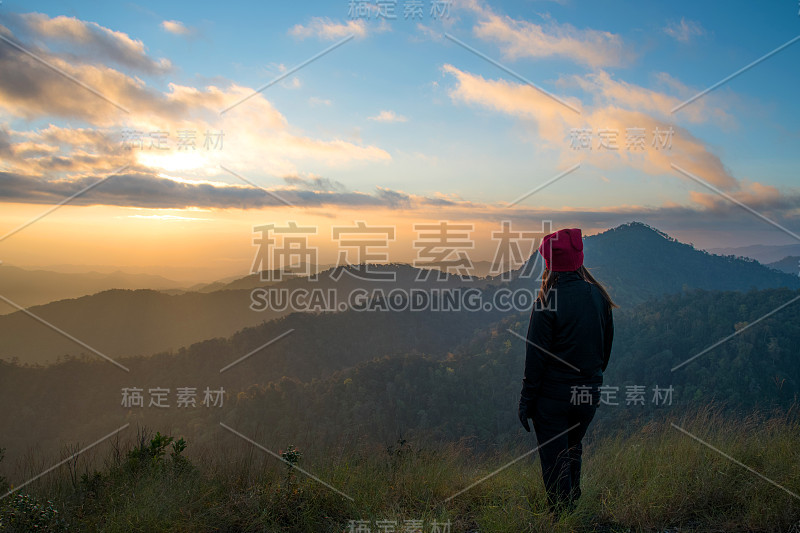 女性旅游徒步度假和旅游。女游客站在泰国清迈的露营地欣赏冬季山上日落、日出的山景。