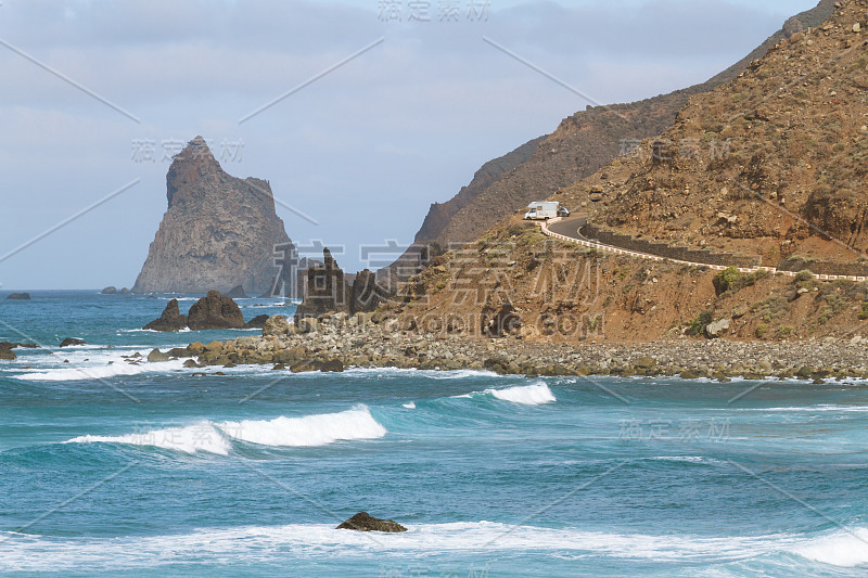 海岸线上遥远的公路紧挨着海滩，海浪汹涌