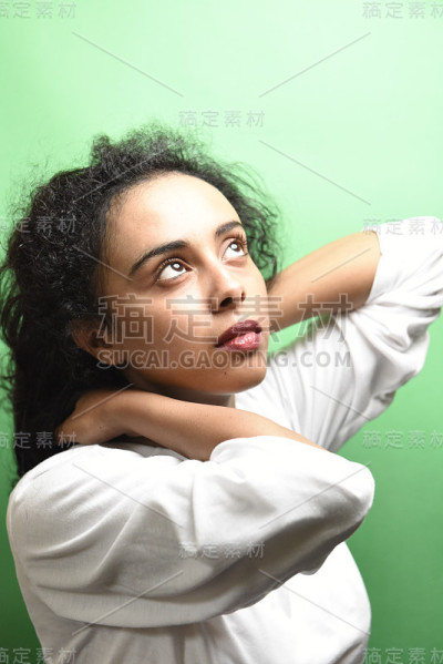 有着一头黑发的中东年轻女子。室内照片的奇妙女性模特在绿色的背景。