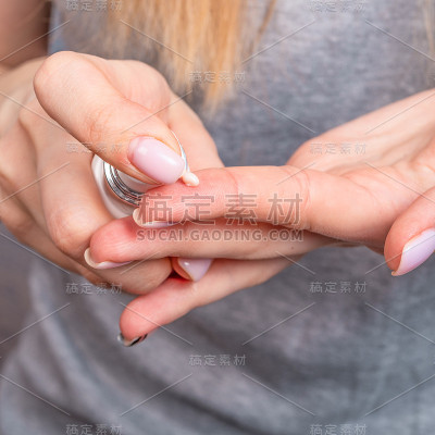 那位妇女在手上干燥的皮肤上挤了一管保湿霜