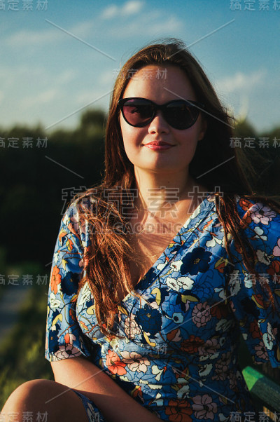 肖像美丽性感的女孩在时尚的花裙子和太阳镜