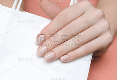 美丽的女性手与米色指甲设计