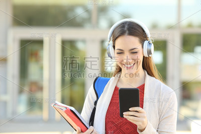 快乐的学生在校园里用手机听音乐