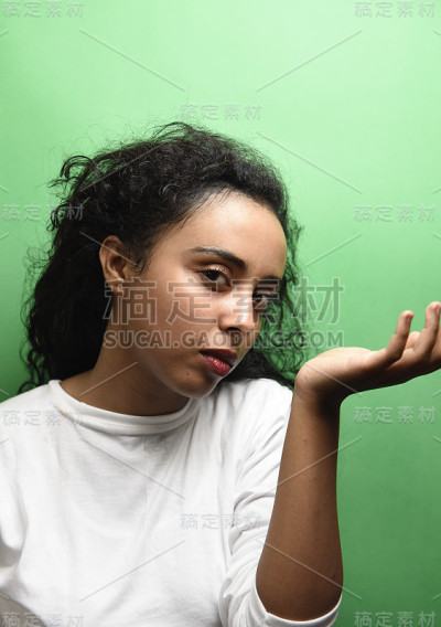 美丽的非洲女孩闻她的香水在绿色的背景