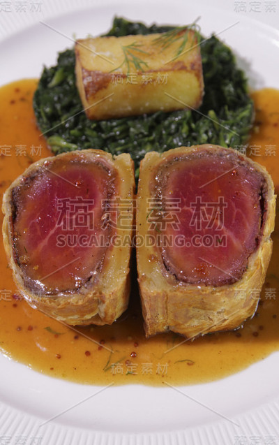惠灵顿牛肉片配菠菜和炸土豆片。