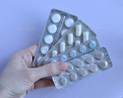 手里拿着彩色药丸的泡罩包装。