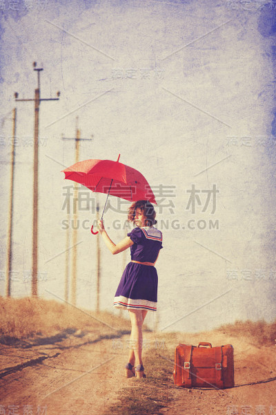带着行李箱的黑发美女在球场上