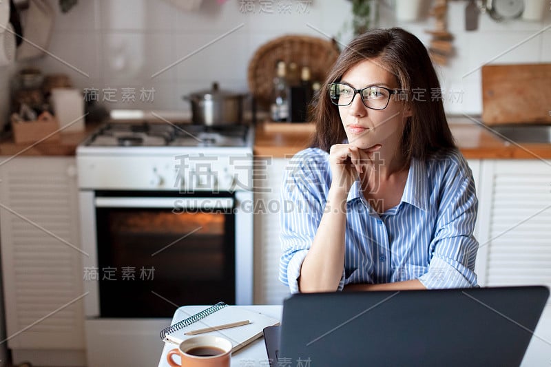 在家办公的年轻女性。女孩自由职业者使用笔记本电脑和互联网。