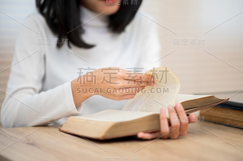 一位穿着白衬衫的亚洲女学生坐在大学里读书