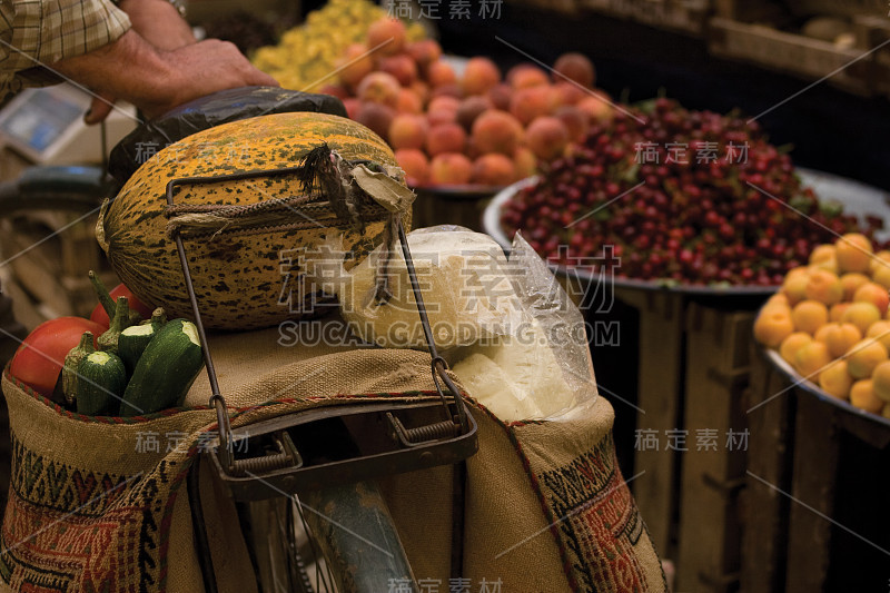 近距离的传统街头市场出售有机食品。西瓜、南瓜、奶酪、西红柿都装在一个鞍袋里，挂在自行车上。