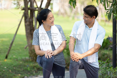 年老的亚洲夫妇在户外锻炼和伸展，在公园里锻炼