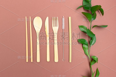 绿叶和竹制餐具。在棕色背景上零浪费配件。