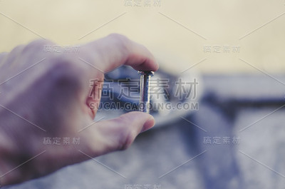一个男人手里拿着一个小螺栓