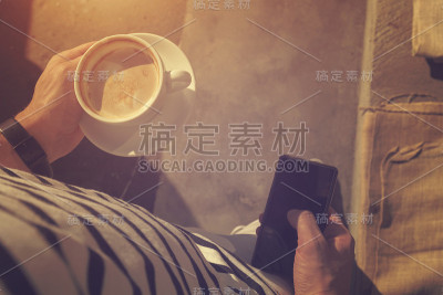 在户外喝咖啡玩手机的嬉皮士。